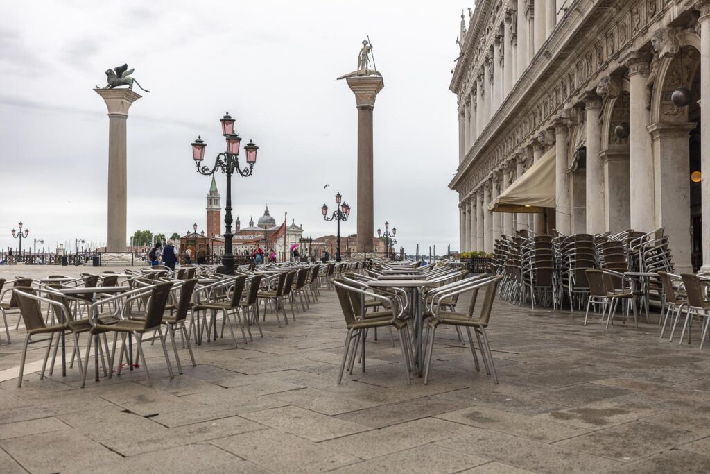 Blick auf den Glockenturm von San Giorgio Maggiore über die Piazzetta San Marco. Hier siehst du die Markussäule mit dem geflügelten Löwe links und den Heiligen Theodore mit dem Speer rechts.